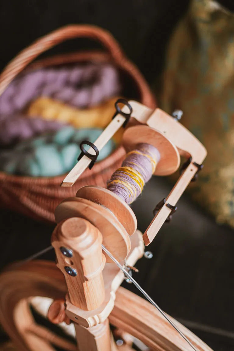 Spinnkopf des Sonata Encore Spinnrads mit gesponnener violett-gelber Wolle im Fokus